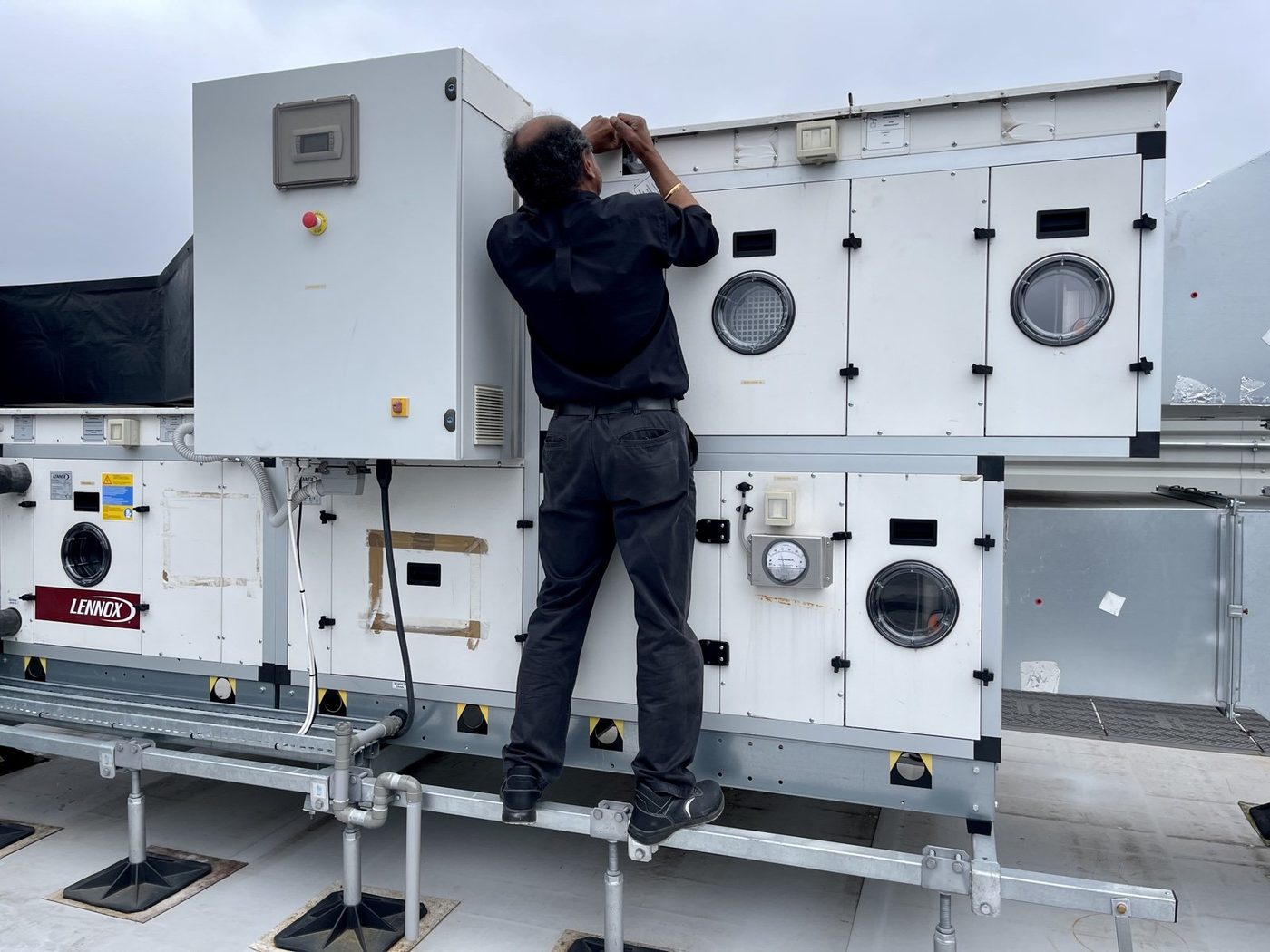 Engineer servicing a rooftop Lennox AHU